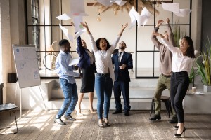 Picture of Funny happy multiracial corporate team people dancing toss papers